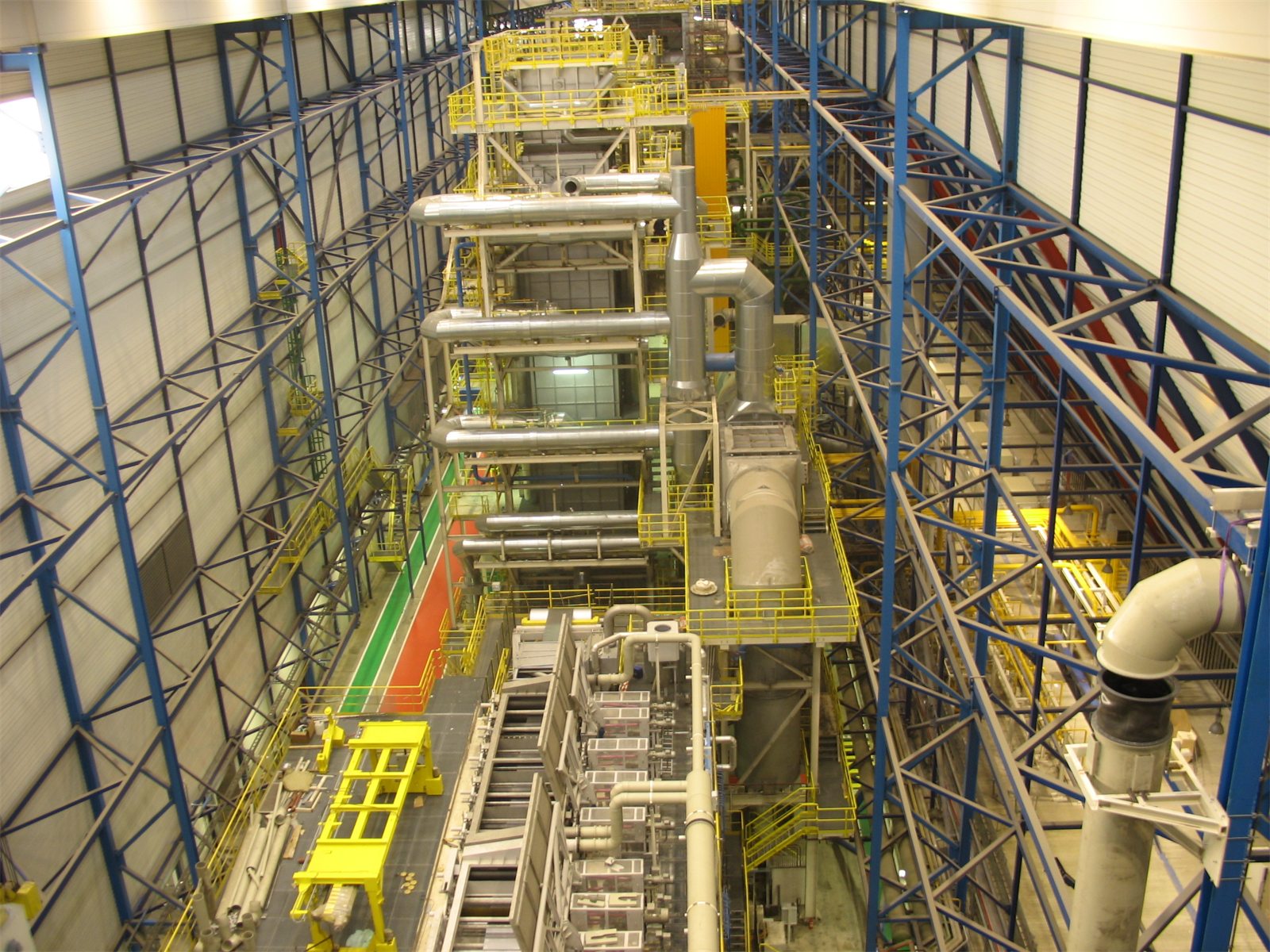 Hall of the continuous galvanising line seen from above, with the line, yellow platforms and piping