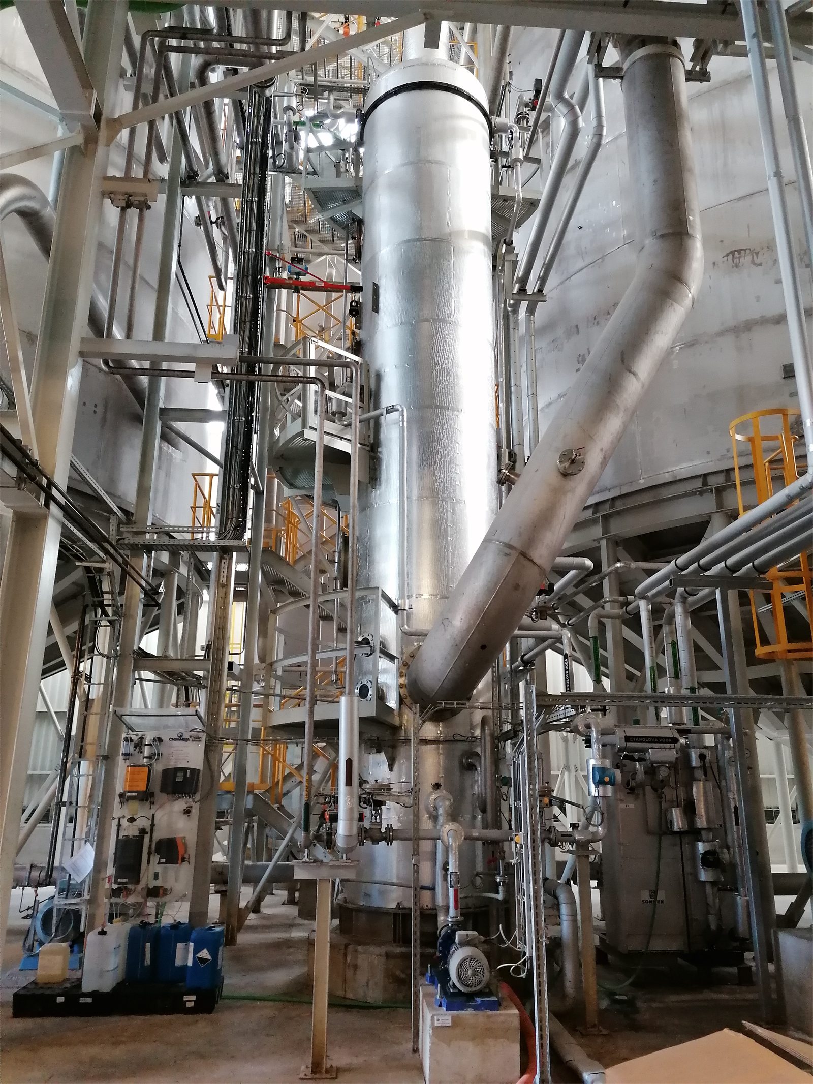 Insulated stainless-steel process column in the ENVIRAL bioethanol plant, with platforms and piping